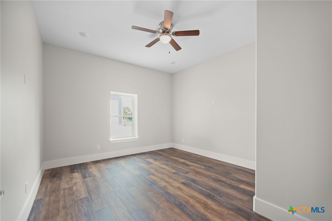 2062 Harrison Avenue Port O'Connor, TX 77982 - Photo 37 of 48 an empty room with wooden floor and windows