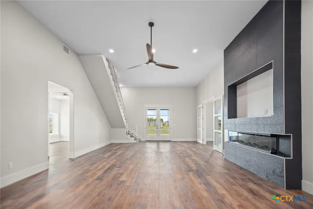 a view of an empty room and window with wooden floor