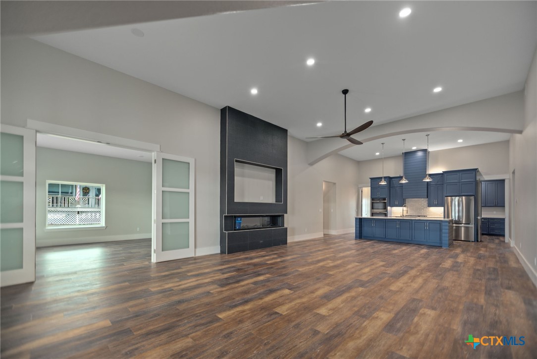 2062 Harrison Avenue Port O'Connor, TX 77982 - Photo 8 of 48 a large kitchen with kitchen island a stove a refrigerator a sink dishwasher with a dining table and chairs with wooden floor