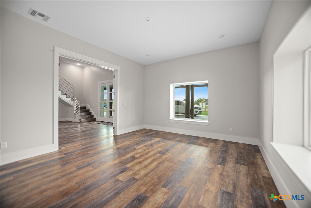 2062 Harrison Avenue Port O'Connor, TX 77982 - Photo 9 of 48 a view of an empty room with wooden floor and a window