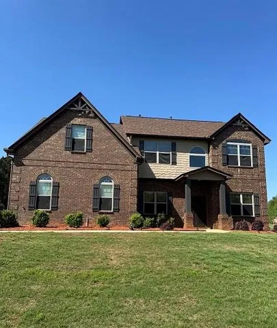 a front view of a house with a garden