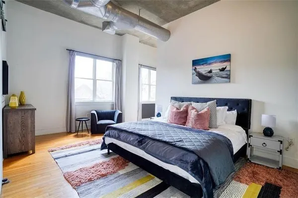 a bedroom with a bed and wooden floor