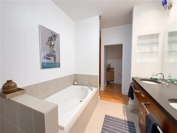 a spacious bathroom with a tub sink and mirror