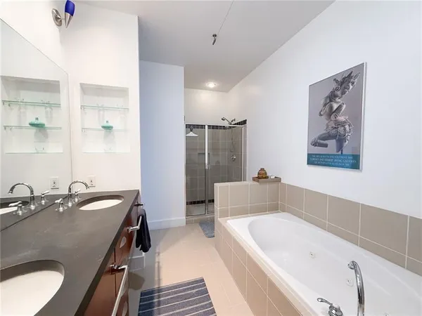 a bathroom with a tub a sink and mirror