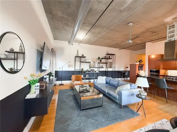 a living room with furniture a mirror on the table and a large window