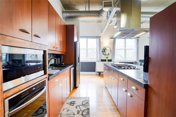a large kitchen with stainless steel appliances granite countertop a stove and a sink