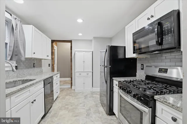 a kitchen with stainless steel appliances granite countertop a refrigerator and a sink