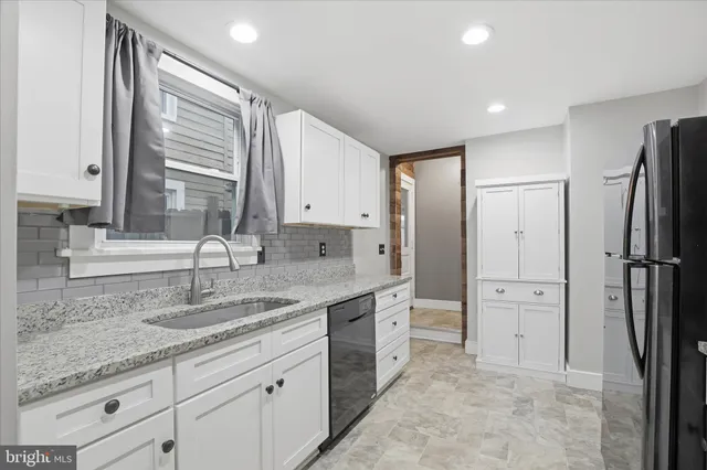 a kitchen with granite countertop a sink and cabinets
