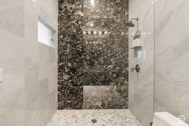 3652 South Cypress Road Hurricane, UT 84737 - Photo 25 of 81 Shower featuring a patterned stone accent wall, light-toned tile walls, a built-in shower niche, a glass shower panel, and a mosaic tile floor