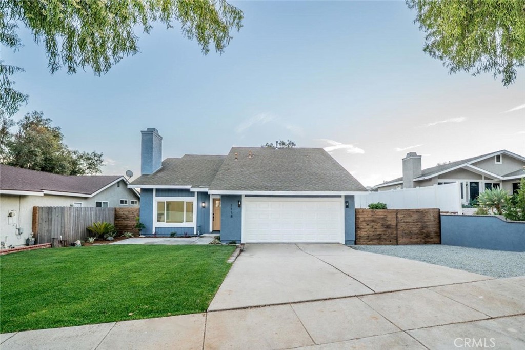 a front view of a house with a garden and yard