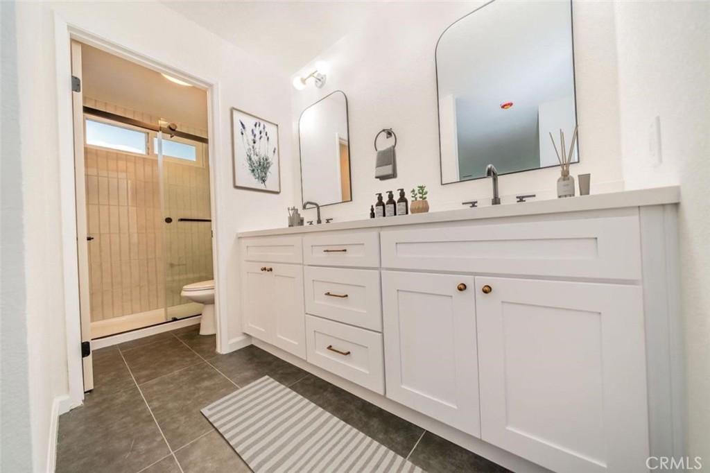1118 Fallbrook Drive Corona, CA 92878 - Photo 14 of 30 a spacious bathroom with a double vanity sink a mirror and a toilet