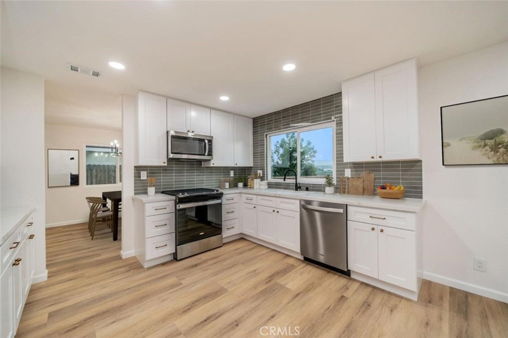1118 Fallbrook Drive Corona, CA 92878 - Photo 6 of 30 a kitchen with a sink wooden floor and stainless steel appliances