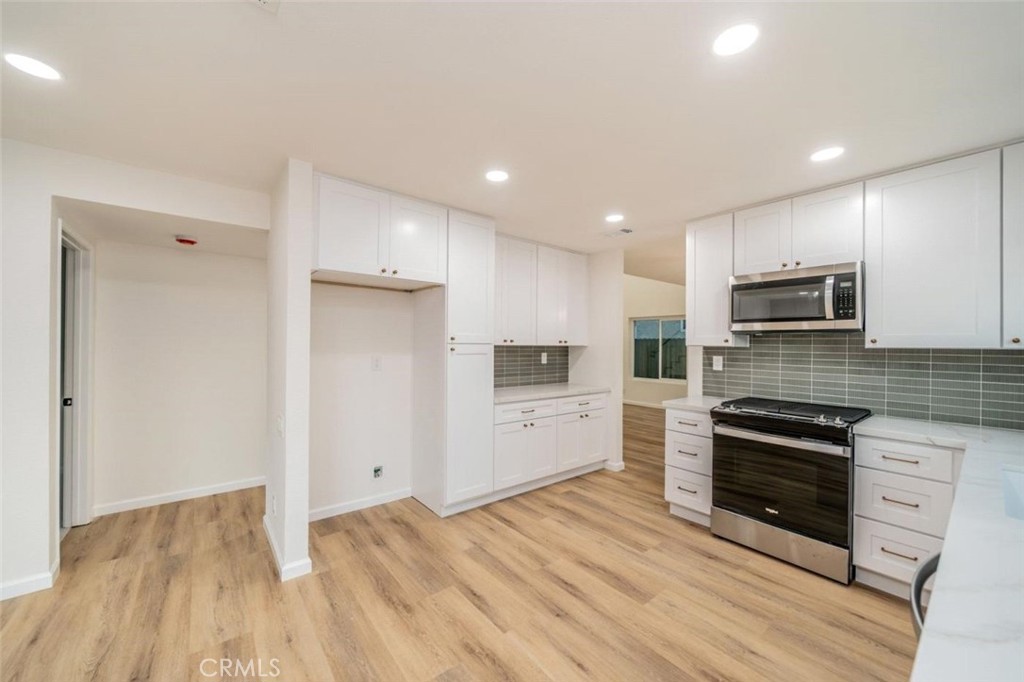 1118 Fallbrook Drive Corona, CA 92878 - Photo 7 of 30 a kitchen with granite countertop a refrigerator and a stove top oven