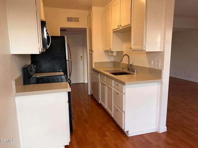 a kitchen with stainless steel appliances a sink stove and refrigerator