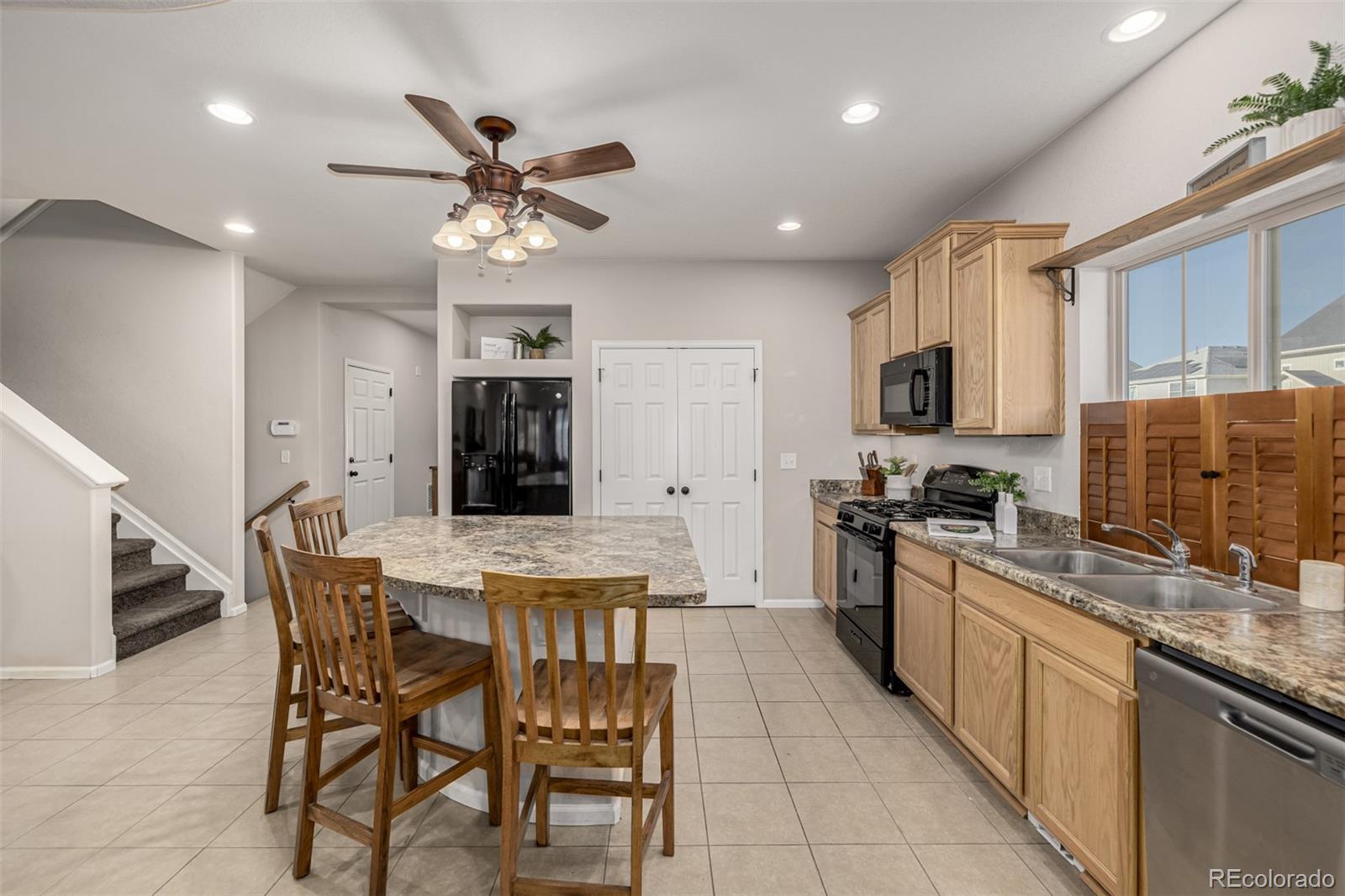 5568 Ceylon Street Denver, CO 80249 - Photo 13 of 43 a kitchen with stainless steel appliances granite countertop a stove top oven a sink a stove a dining table and chairs