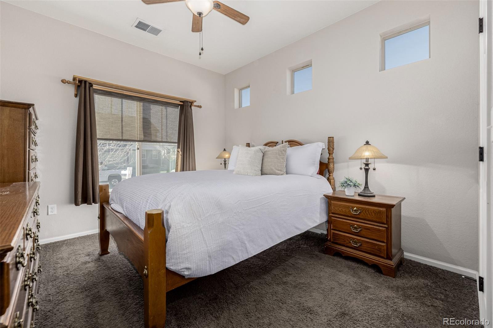 5568 Ceylon Street Denver, CO 80249 - Photo 20 of 43 a bedroom with a bed and a chandelier
