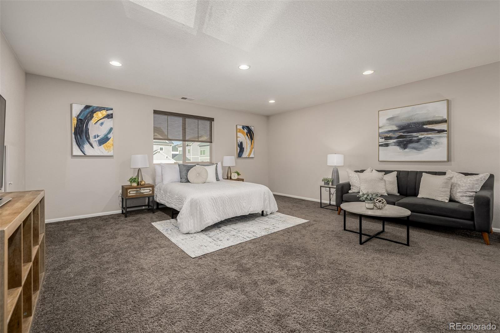 5568 Ceylon Street Denver, CO 80249 - Photo 25 of 43 a spacious bedroom with a bed and paintings on the wall