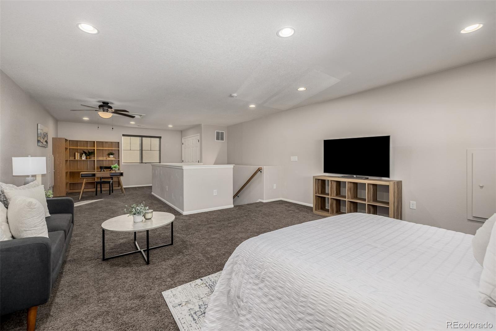 5568 Ceylon Street Denver, CO 80249 - Photo 27 of 43 a bedroom with a bed and a flat screen tv
