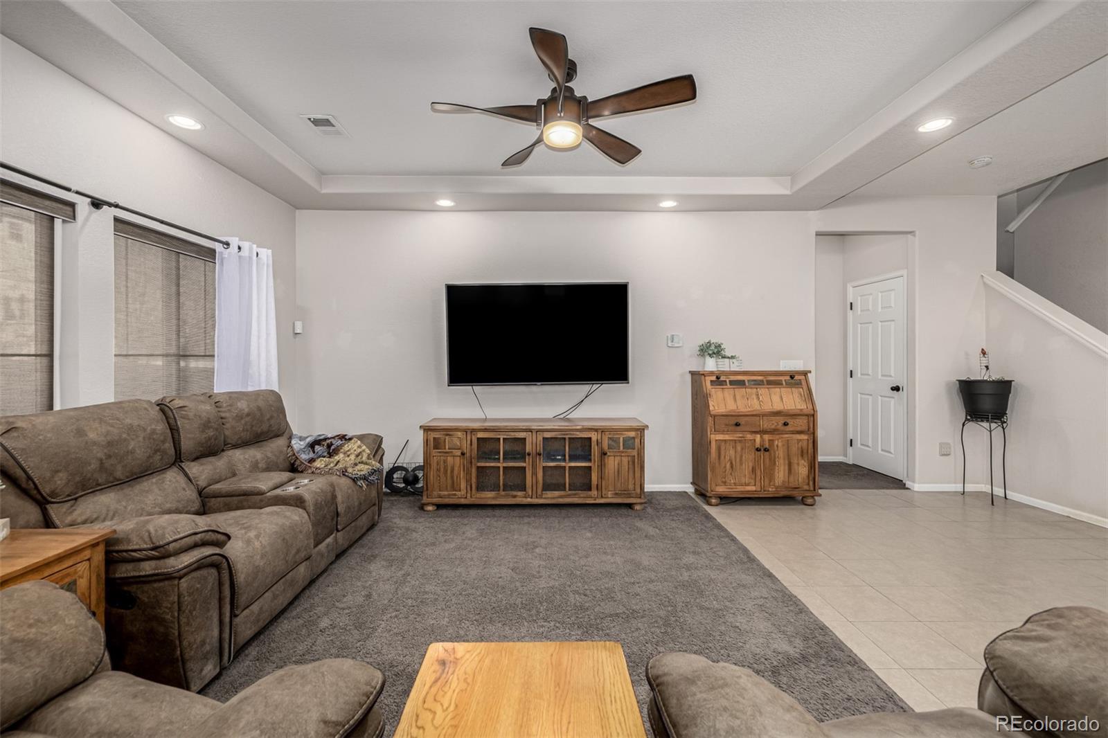 5568 Ceylon Street Denver, CO 80249 - Photo 6 of 43 a living room with furniture and a flat screen tv