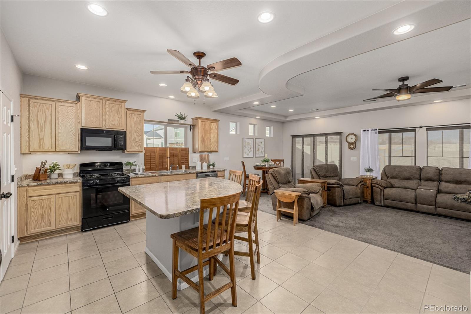5568 Ceylon Street Denver, CO 80249 - Photo 10 of 43 a living room with kitchen island furniture and a kitchen view