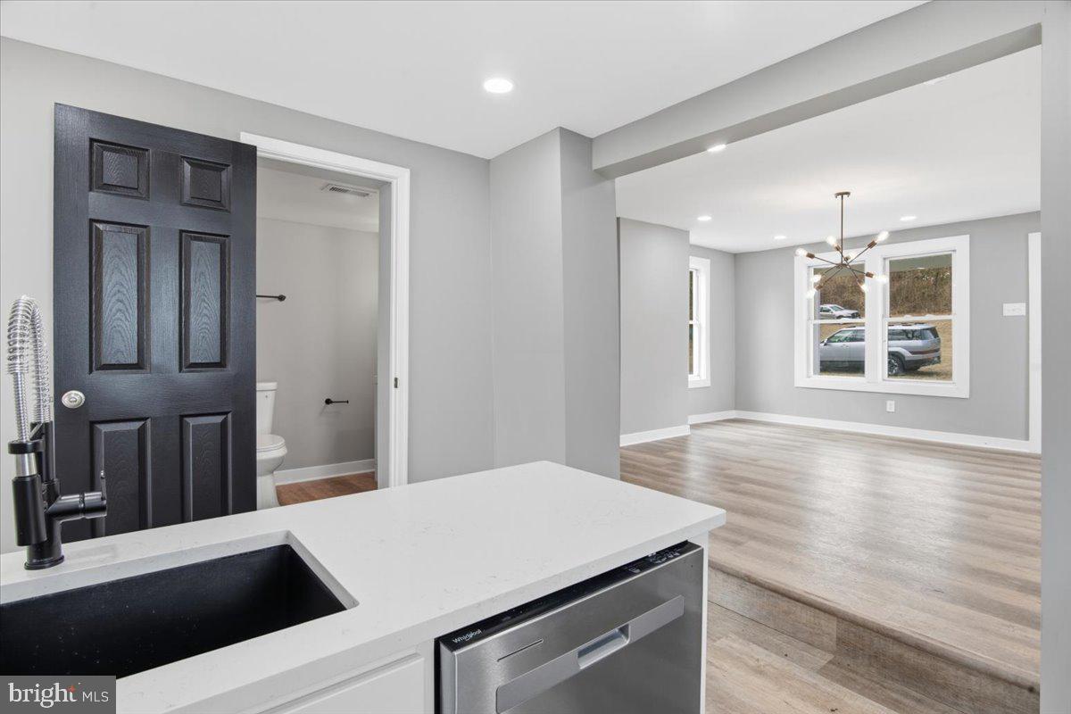 221 Denton Road Federalsburg, MD 21632 - Photo 17 of 33 a view of a kitchen with kitchen island a sink wooden floor and living room view