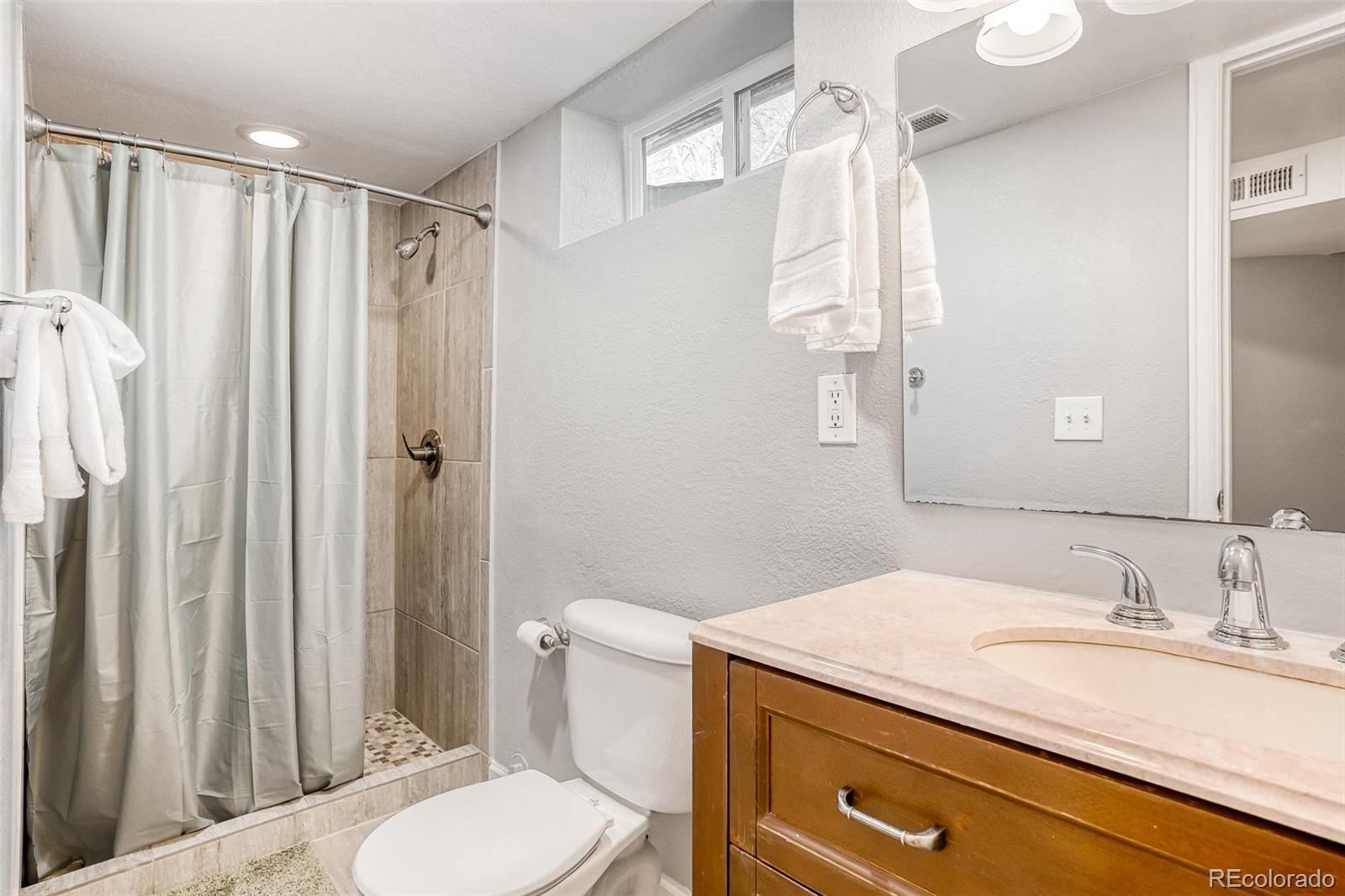 2356 Florence Street Aurora, CO 80010 - Photo 23 of 31 a bathroom with a granite countertop sink toilet and shower