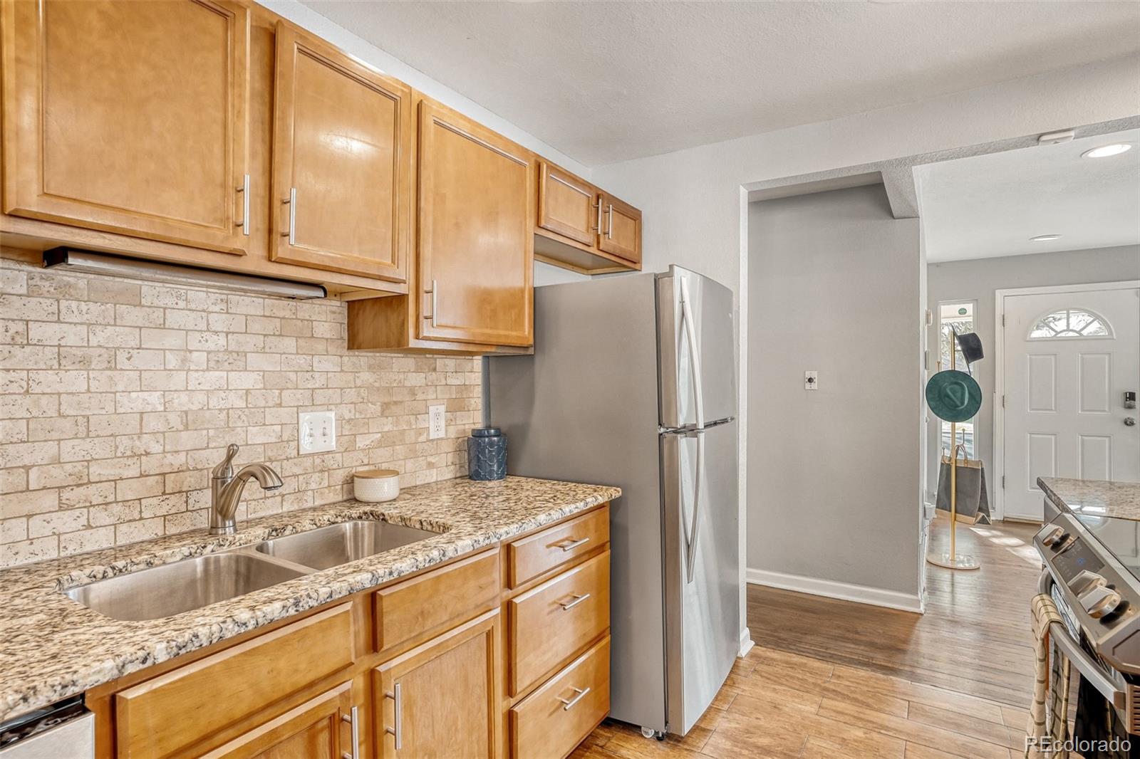 2356 Florence Street Aurora, CO 80010 - Photo 4 of 31 a kitchen with stainless steel appliances granite countertop a refrigerator and a sink