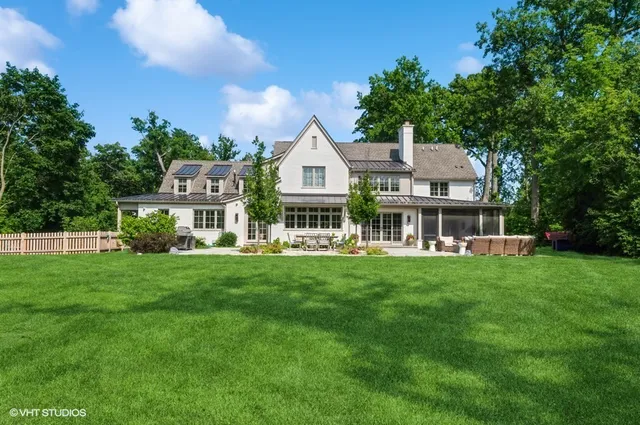 a front view of a house with a garden and trees