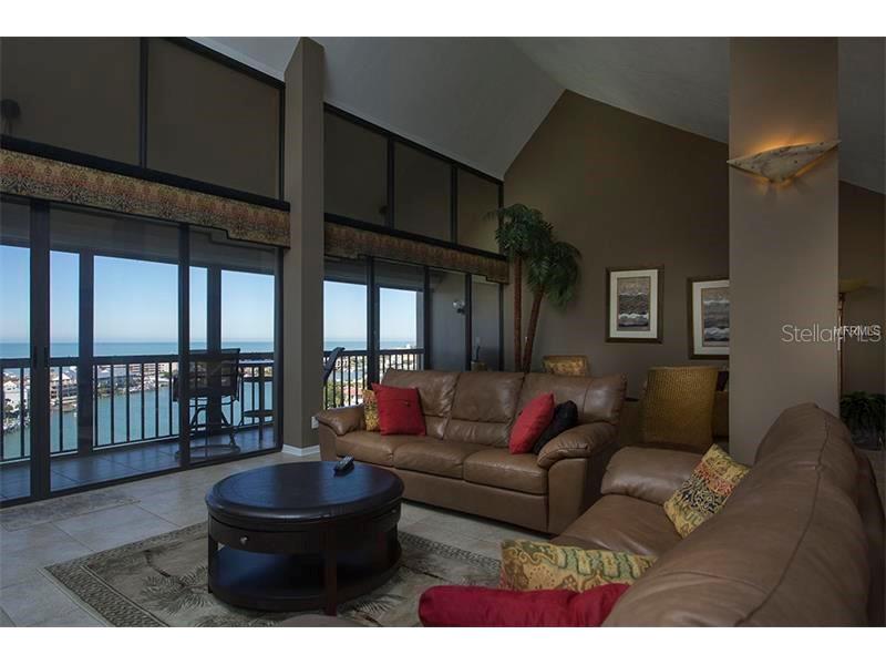 9525 Blind Pass Road, Unit PH2 St. Pete Beach, FL 33706 - Photo 1 of 1 a living room with furniture and a large window