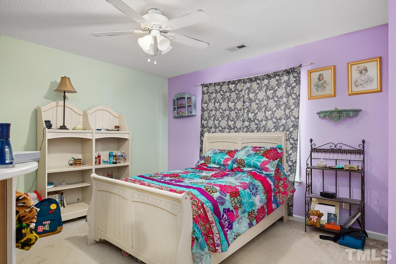 229 Roping Horn Way Willow Spring, NC 27592 - Photo 19 of 30 a bedroom with a bed and a chandelier