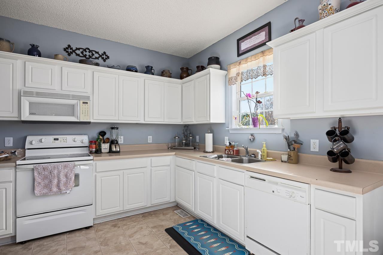 229 Roping Horn Way Willow Spring, NC 27592 - Photo 3 of 30 a kitchen with cabinets appliances a sink and a window