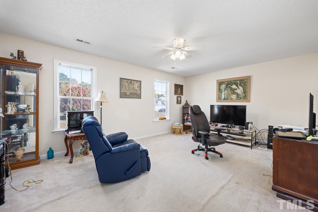 229 Roping Horn Way Willow Spring, NC 27592 - Photo 21 of 30 a living room with furniture and a flat screen tv with wooden floor