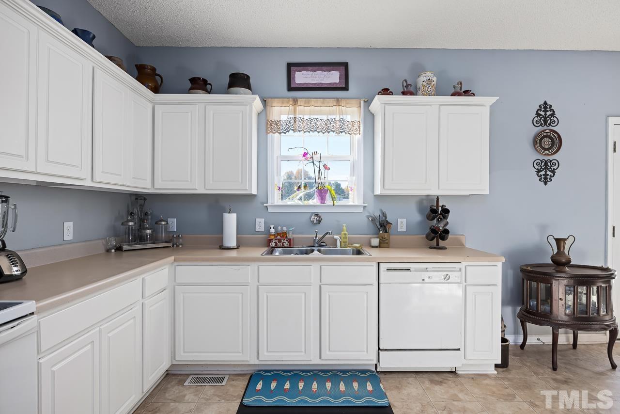 229 Roping Horn Way Willow Spring, NC 27592 - Photo 5 of 30 a kitchen with stainless steel appliances granite countertop a sink and cabinets