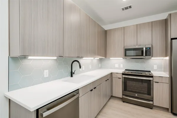 a kitchen with a sink and stainless steel appliances