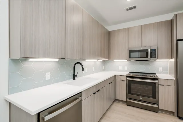 a kitchen with a sink and stainless steel appliances