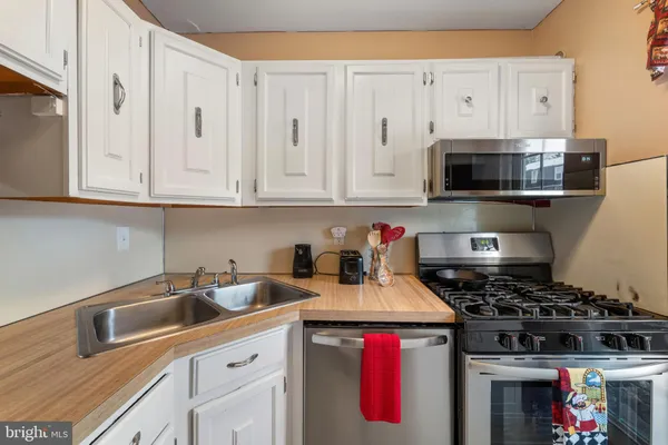 a kitchen with stainless steel appliances granite countertop a stove and a microwave