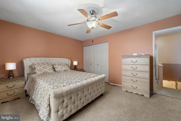 a bedroom with a bed and a ceiling fan