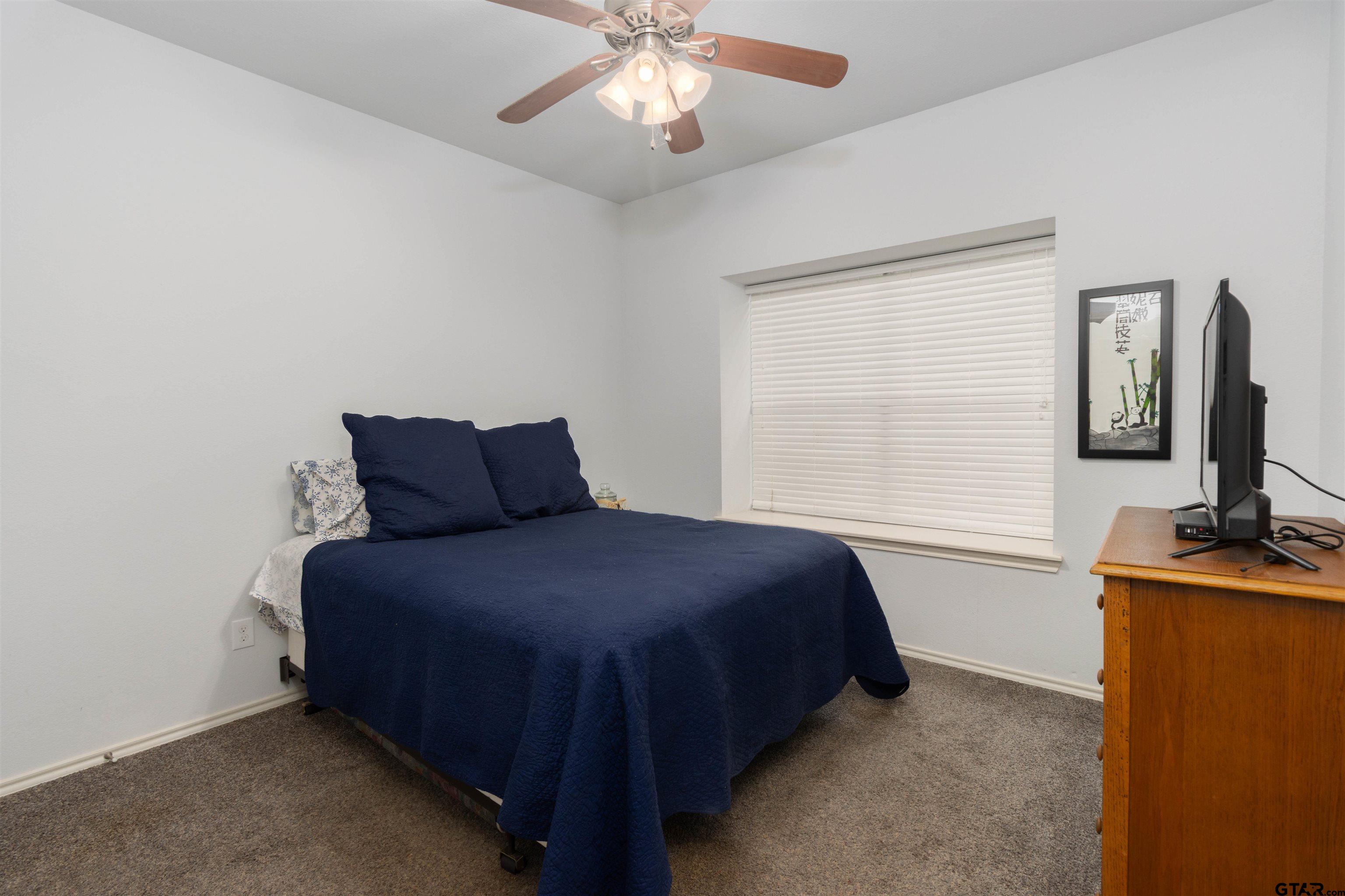 18424 Walnut Circle Flint, TX 75762 - Photo 14 of 26 a bedroom with a bed and a flat tv screen on the dresser