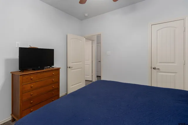 a living room with flat screen tv on dresser and a flat screen tv