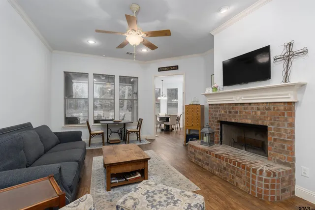 a living room with furniture a flat screen tv and a fireplace