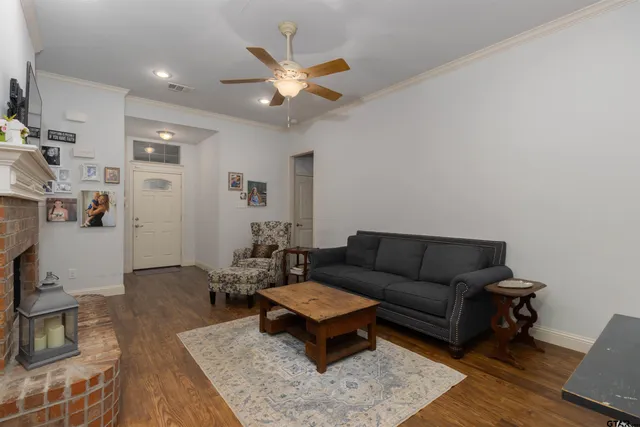 a living room with furniture and a wooden floor