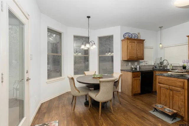 a kitchen with a table chairs and a wooden floor