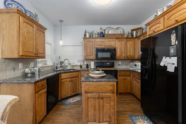 a kitchen with stainless steel appliances granite countertop a stove a sink dishwasher and a refrigerator