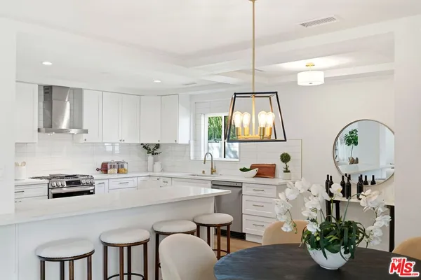 a kitchen with a dining table cabinets and a window