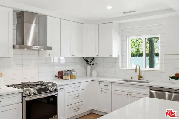 a kitchen with appliances a sink and cabinets
