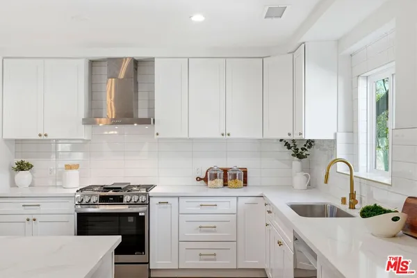 a kitchen with white cabinets and white appliances