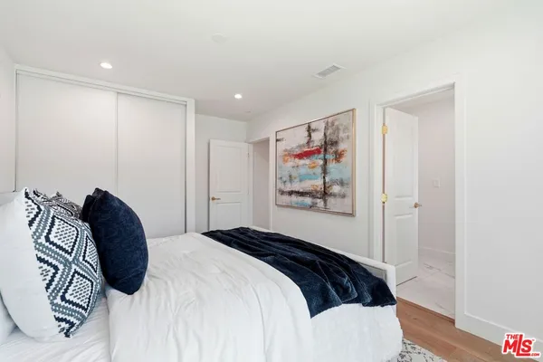 a bedroom with a bed and a painting on the wall