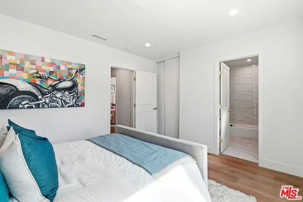 a bedroom with a large bed and a painting on the wall