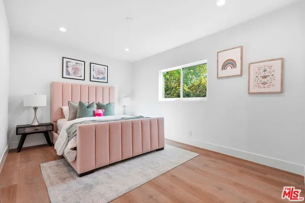 a room with a bed and a painting on the wall