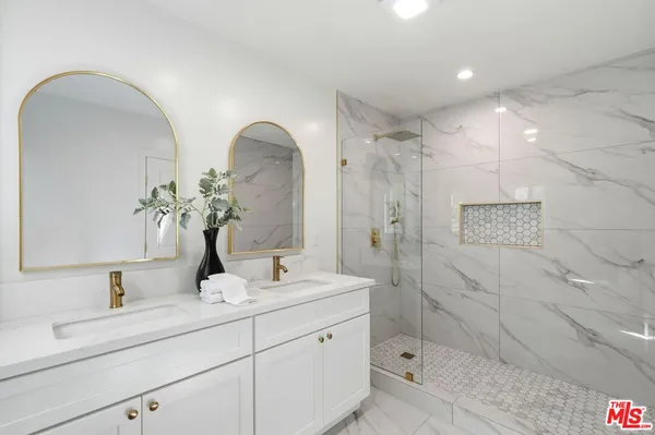 a bathroom with a double vanity sink mirror and shower
